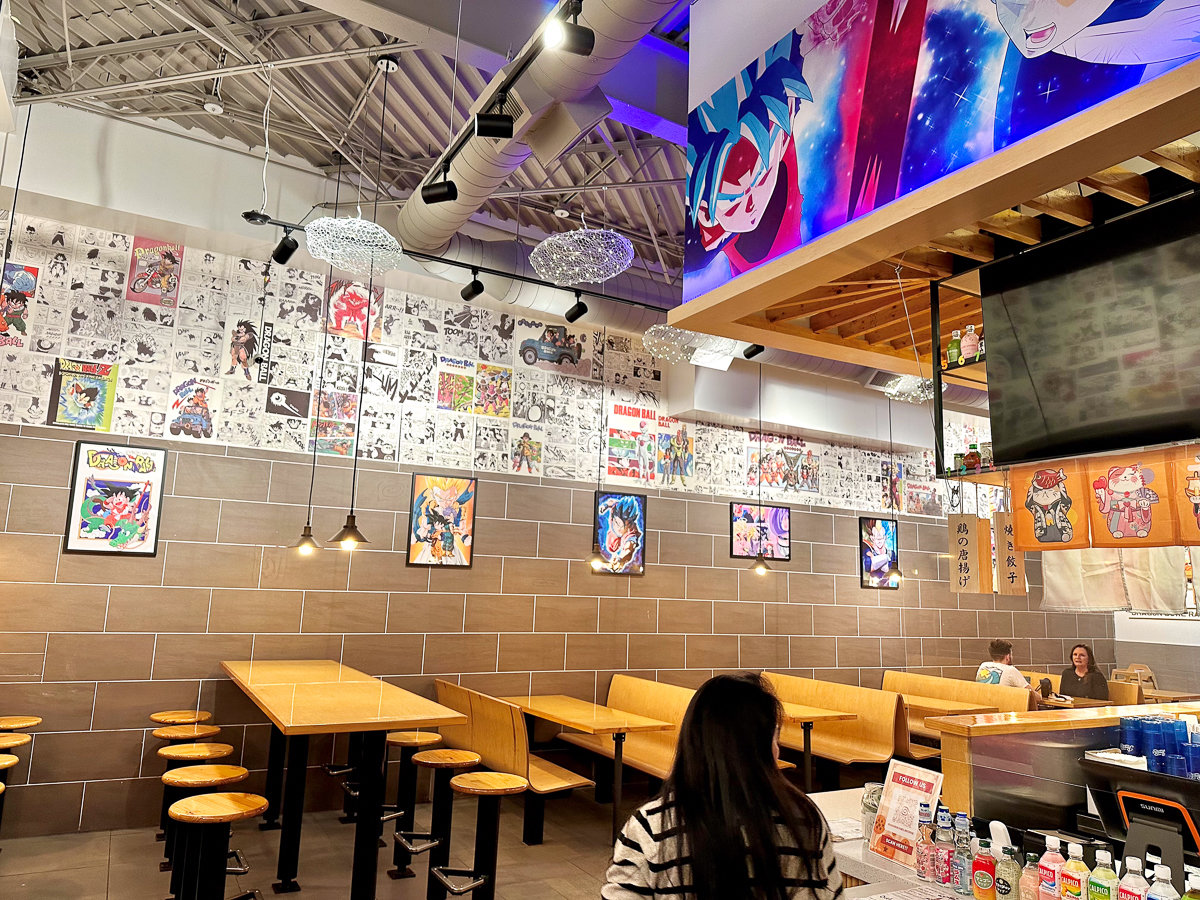 inside restaurant with brown tables and chairs with dragon ball posters